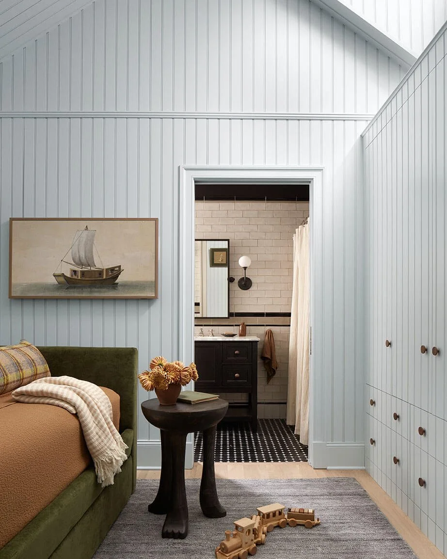 Child's bedroom with sailboat art and a view into a tiled ensuite bathroom in a Philadelphia home by Vestige Home