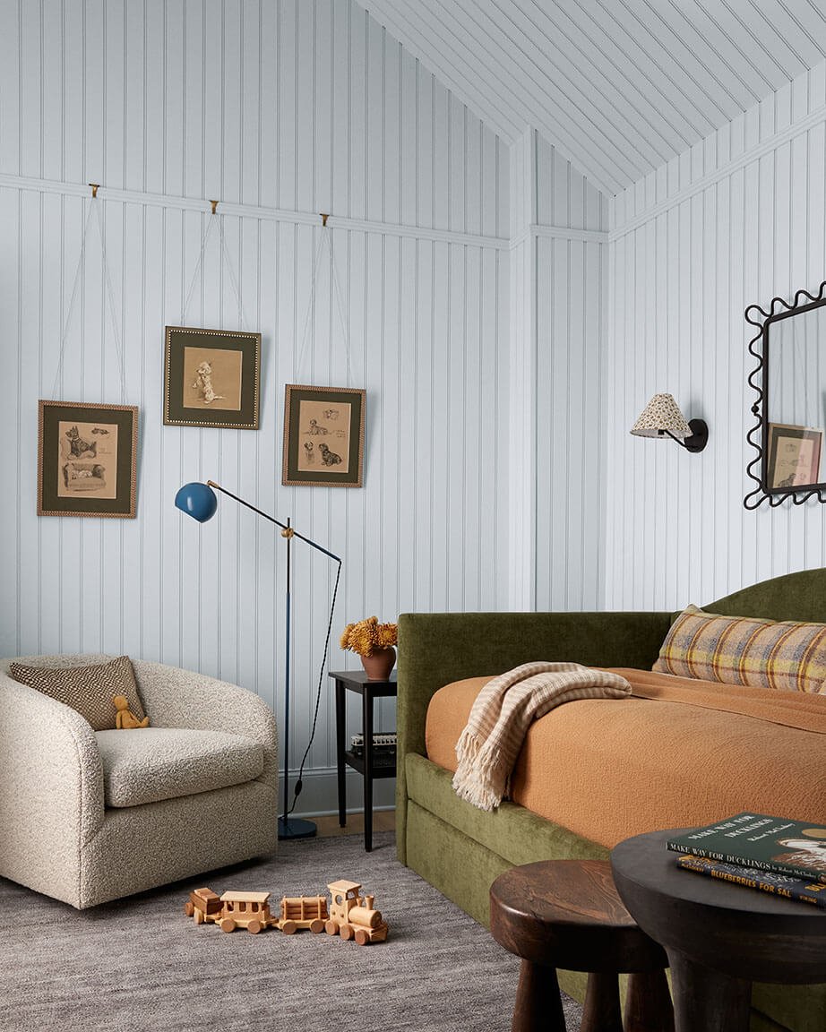 Children's bedroom in a Philadelphia home by Vestige Home with a green velvet daybed and pale blue paneling