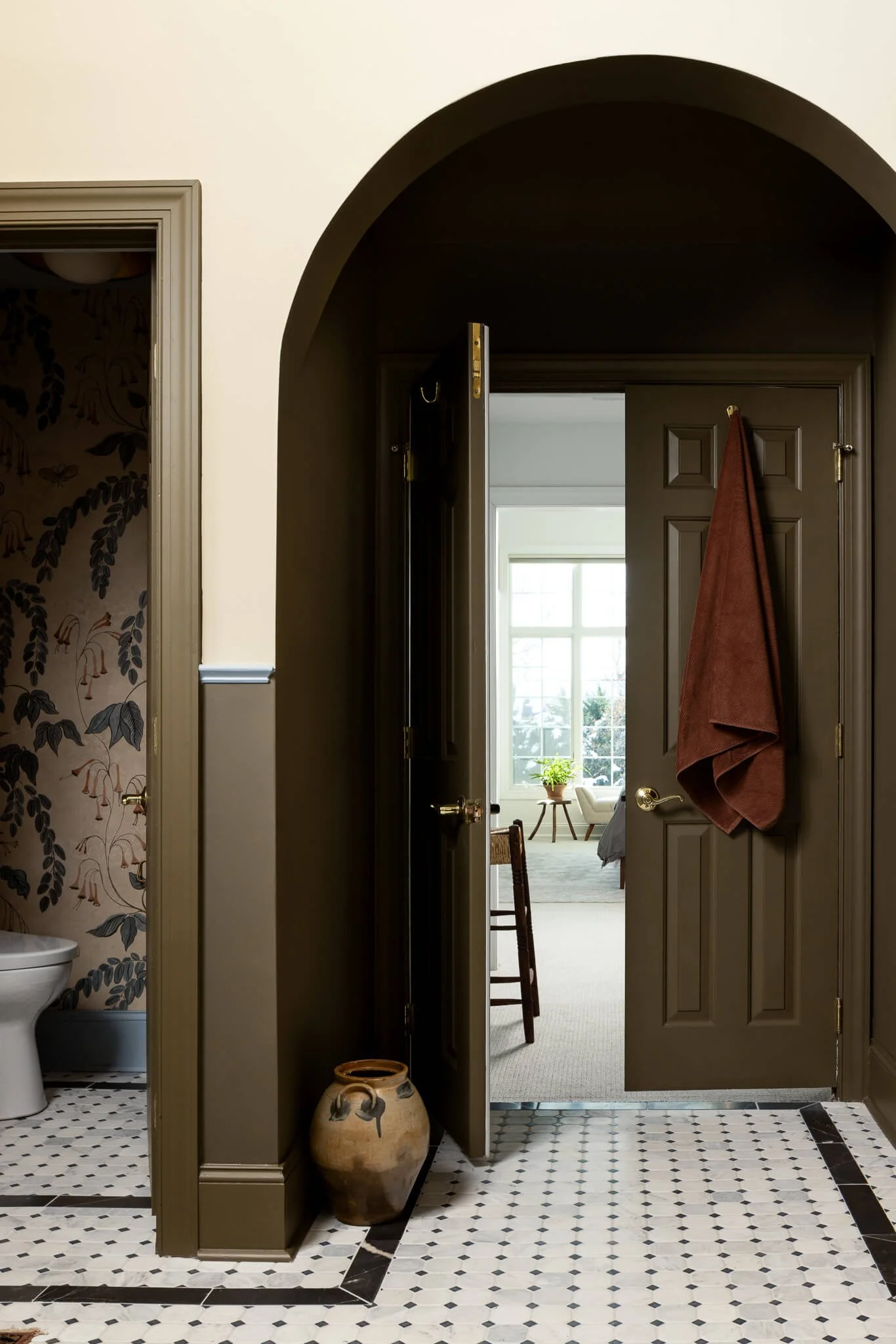 Arched doorway and patterned tile flooring connecting spaces in a Penn Valley, PA luxury bathroom designed by Vestige Home.