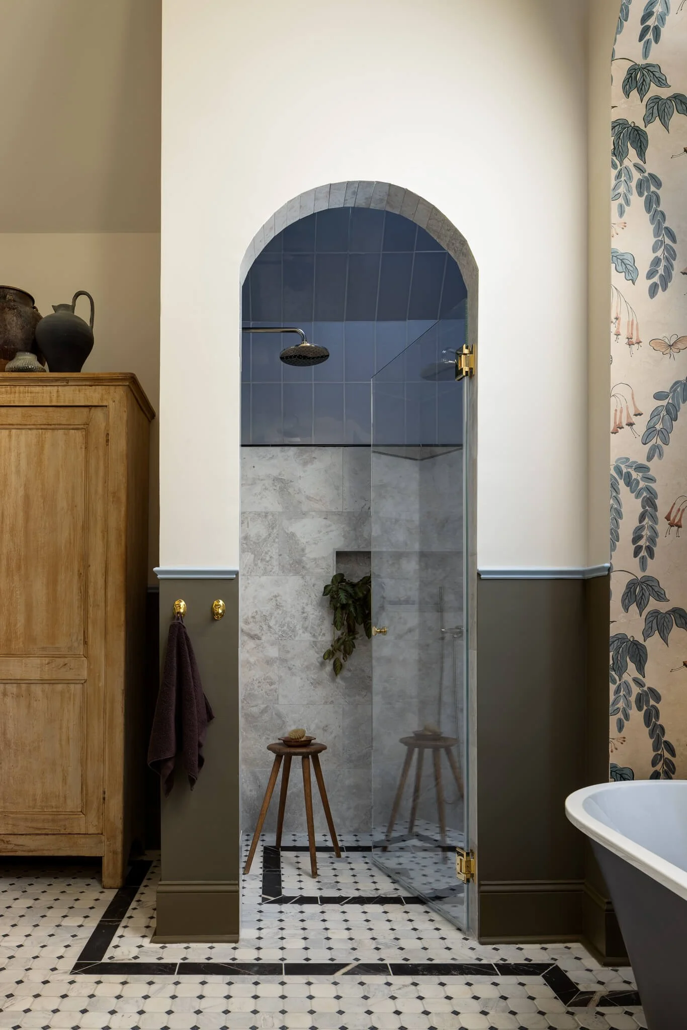 Custom walk-in shower with arched entry, blue tile, and stone finishes in a Penn Valley, PA luxury bathroom remodel.