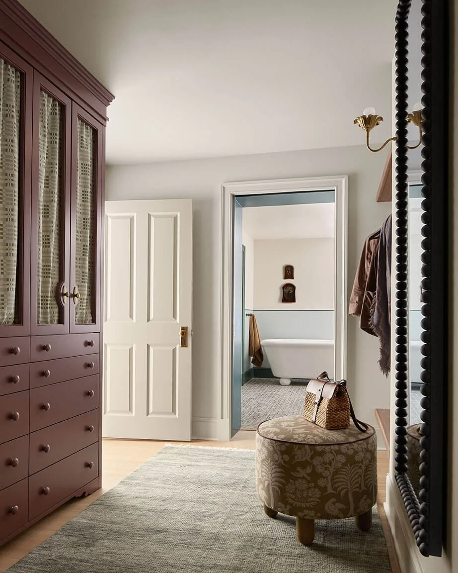 Primary suite dressing area with a plum armoire and view to the bathroom in a Philadelphia home by Vestige Home