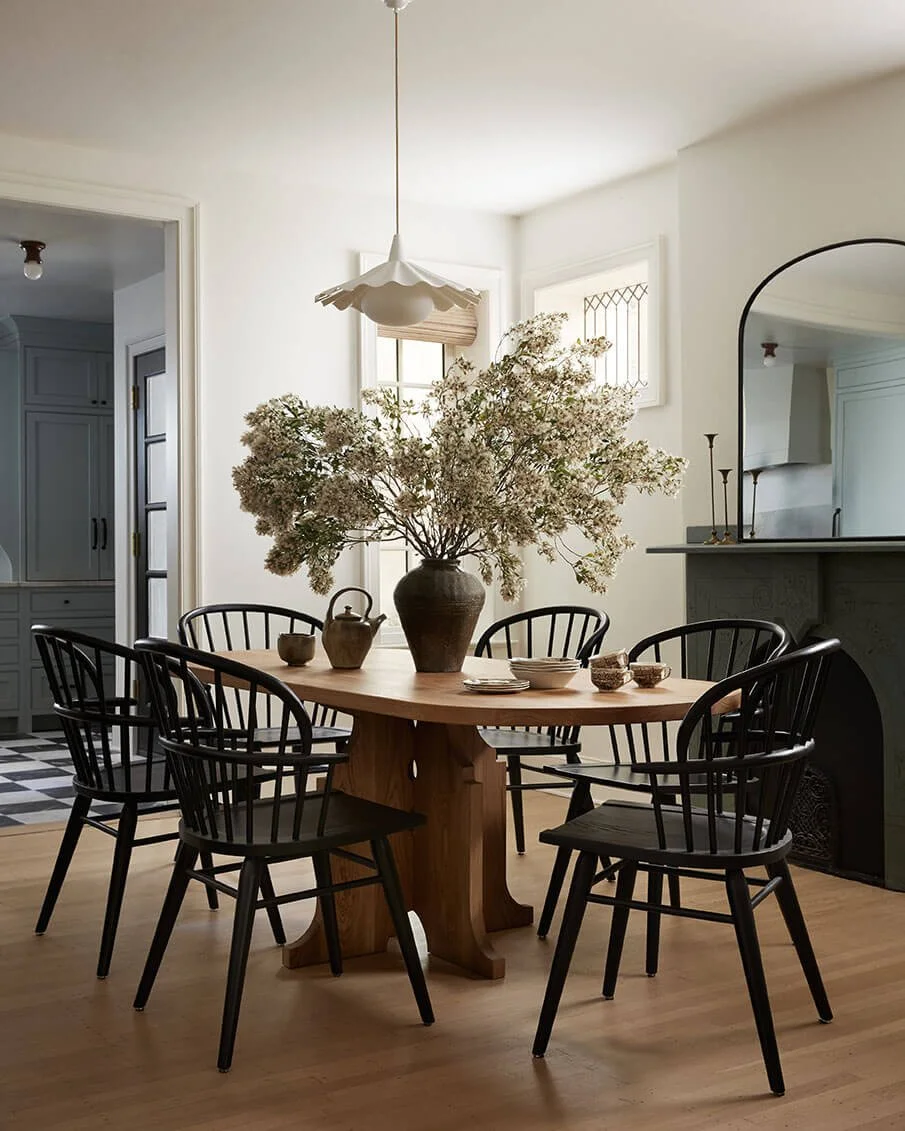 Philadelphia dining room by Vestige Home with a pedestal table, ruffled porcelain pendant light and arched mirror