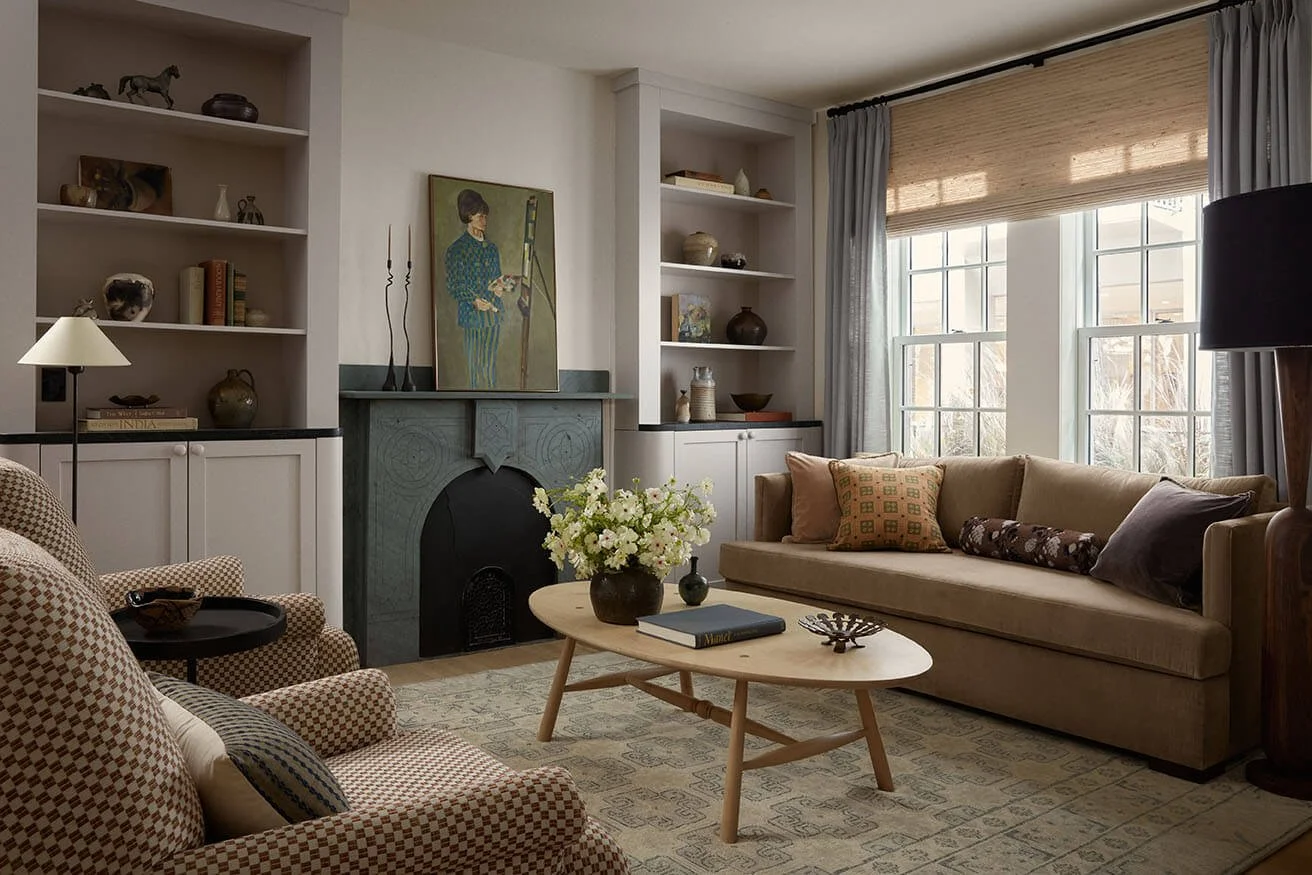 Vestige Home living room in Philadelphia with a carved stone fireplace, camel velvet sofa and custom built-in shelving
