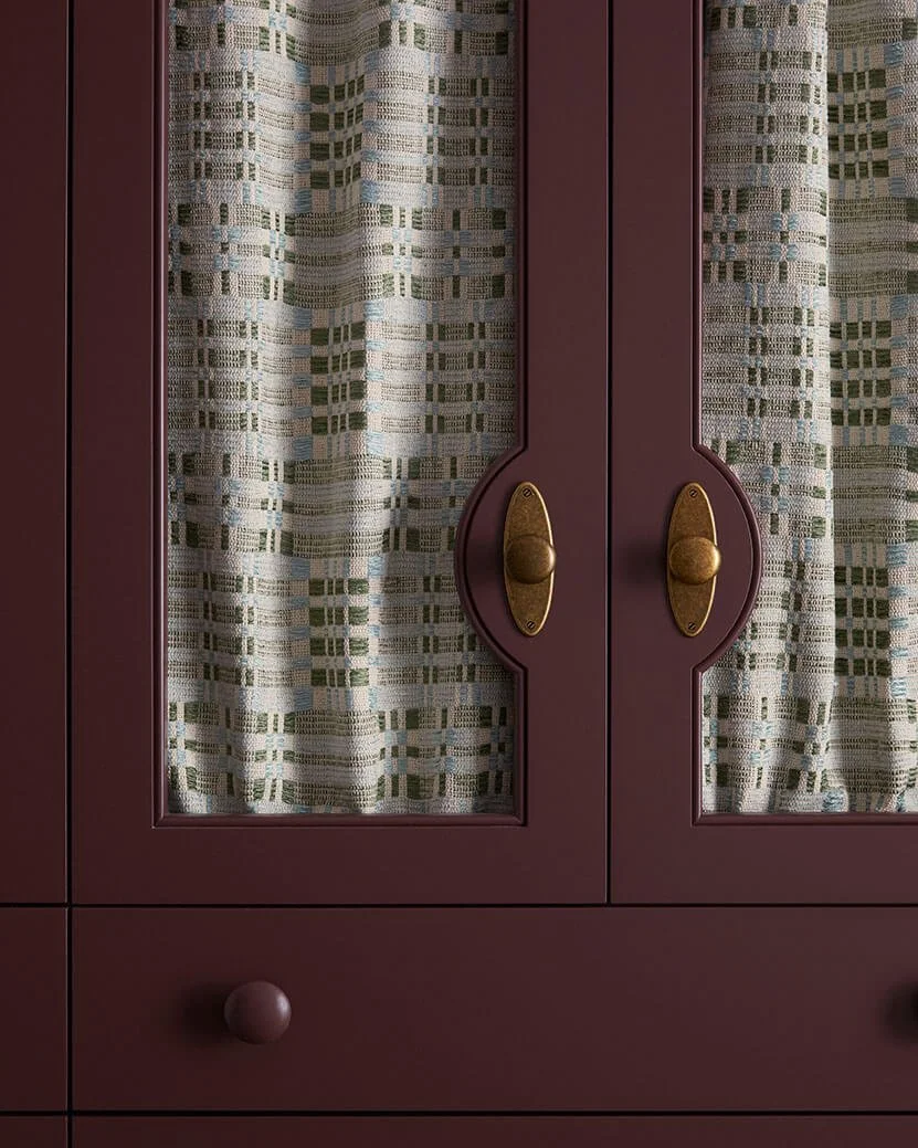 Cabinetry with fabric-panel doors and aged brass latches in a Philadelphia laundry room by Vestige Home