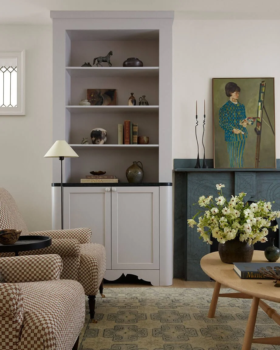 Custom built-in shelving and a carved fireplace styled with pottery in a Philadelphia living room by Vestige Home