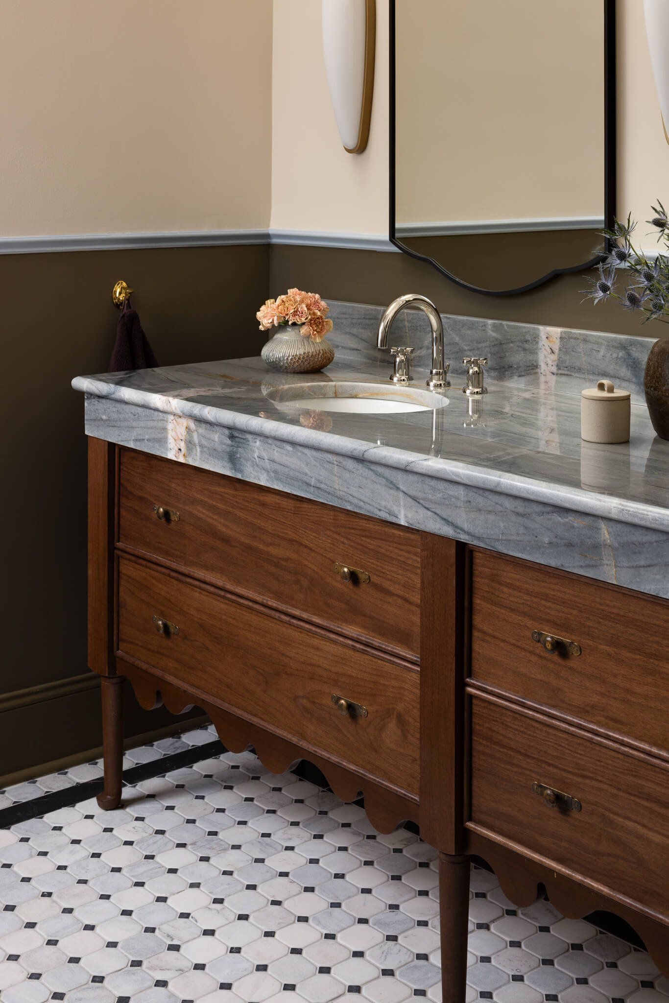 Close-up of custom walnut vanity cabinetry with brass hardware in a luxury Penn Valley bathroom design.