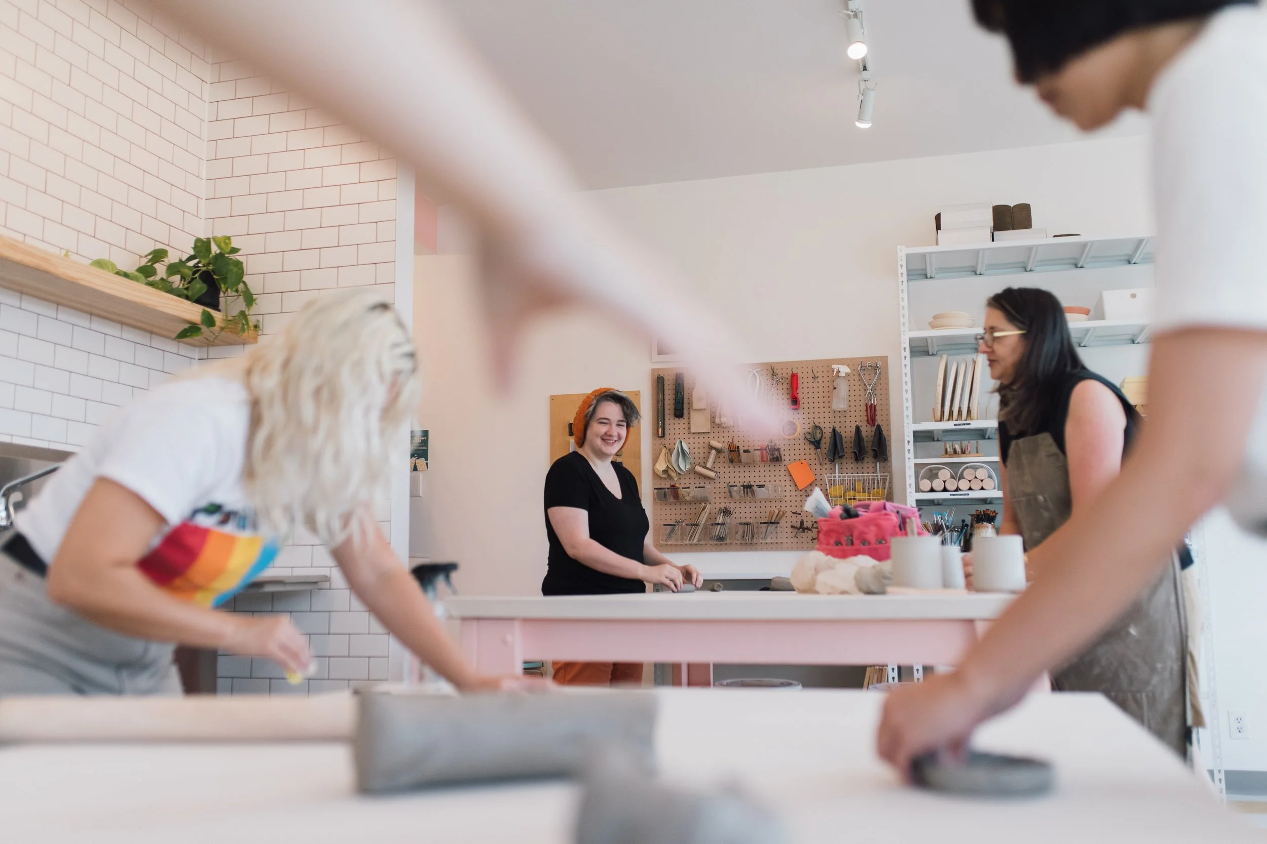A group of people at a table hand building with clay