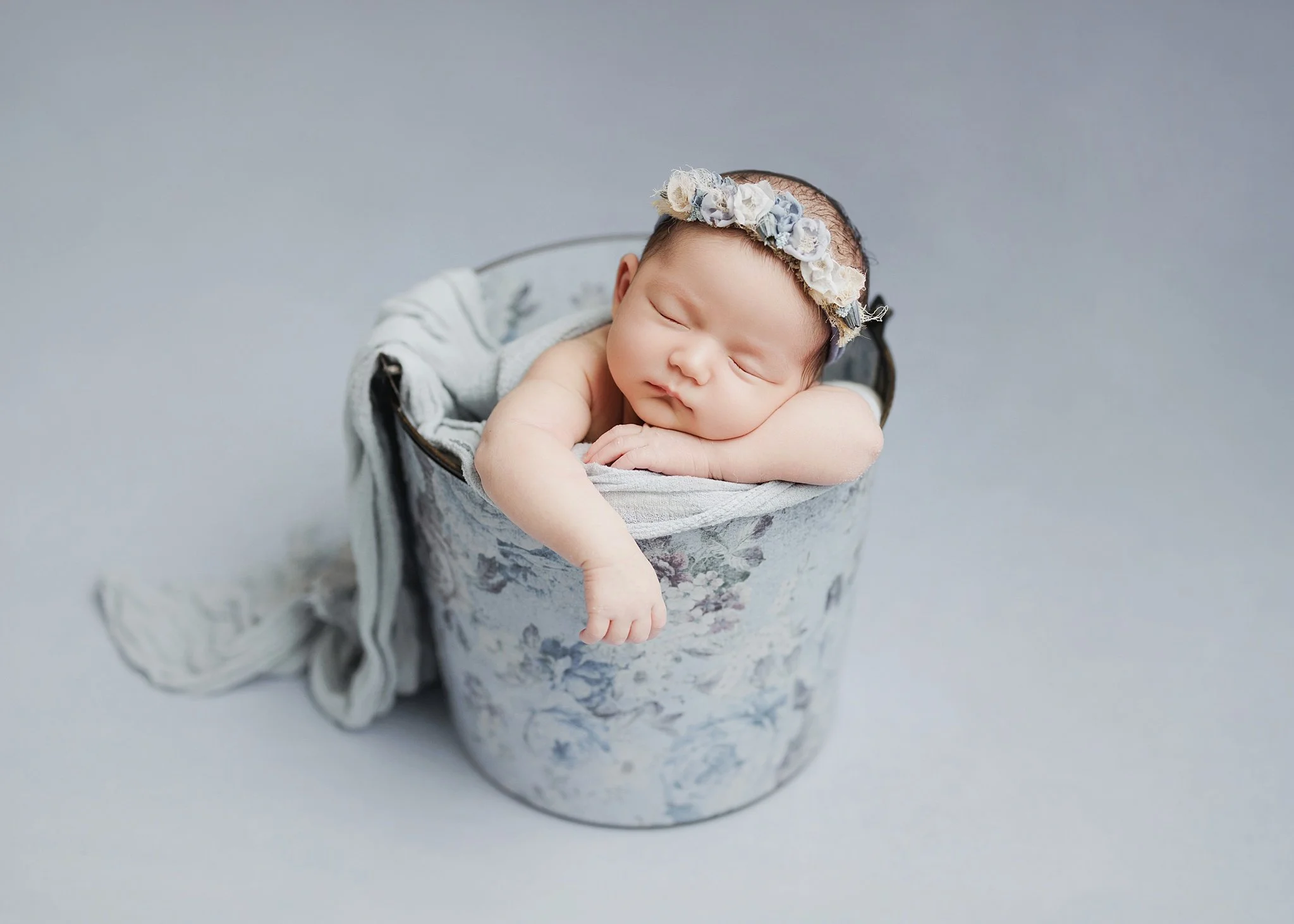 newborn in a blue purple flower bucket