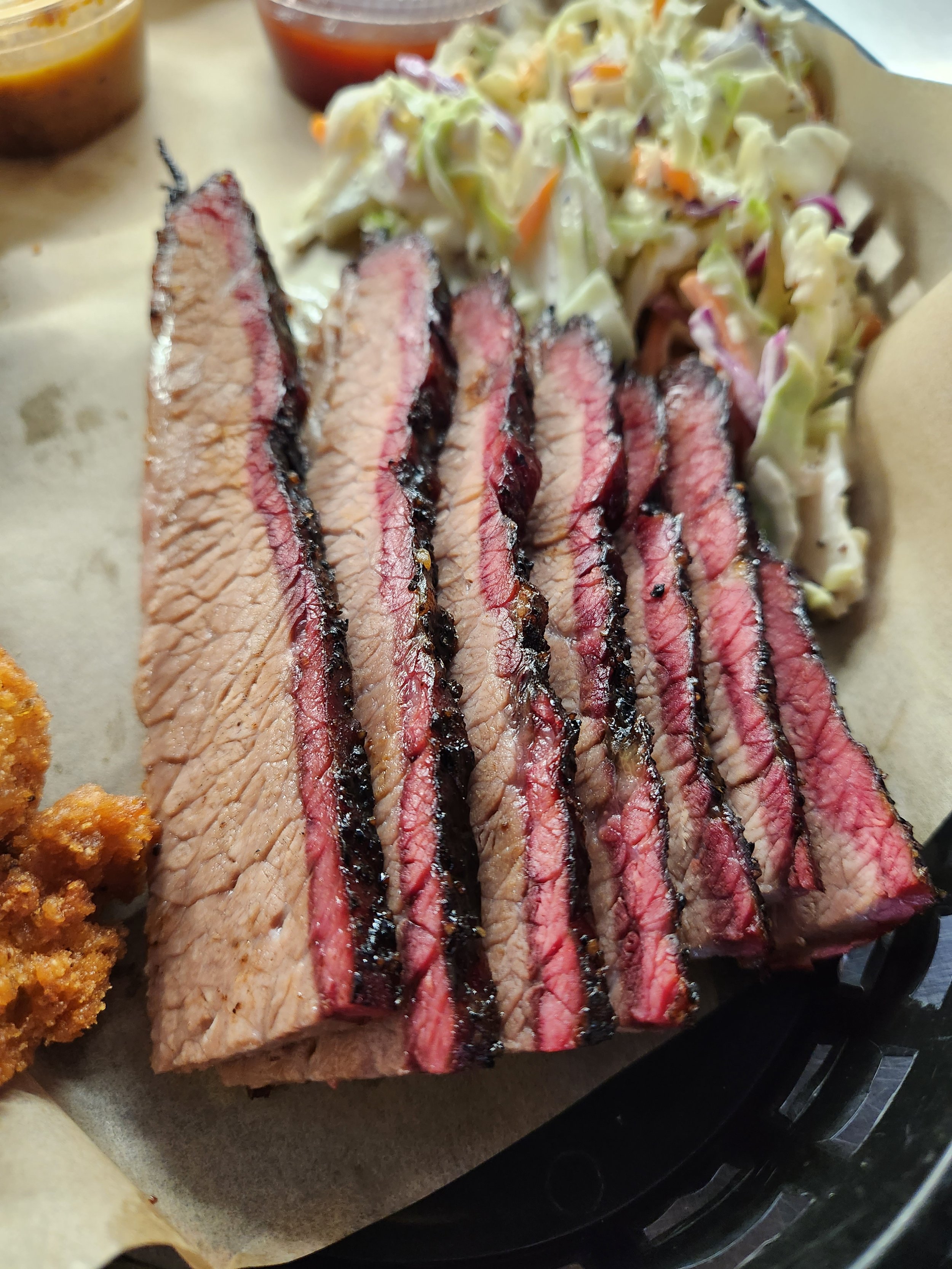 Sliced juicy brisket steak with, coleslaw with cabbage and carrots, and a side of famous jalapeno hush puppies.