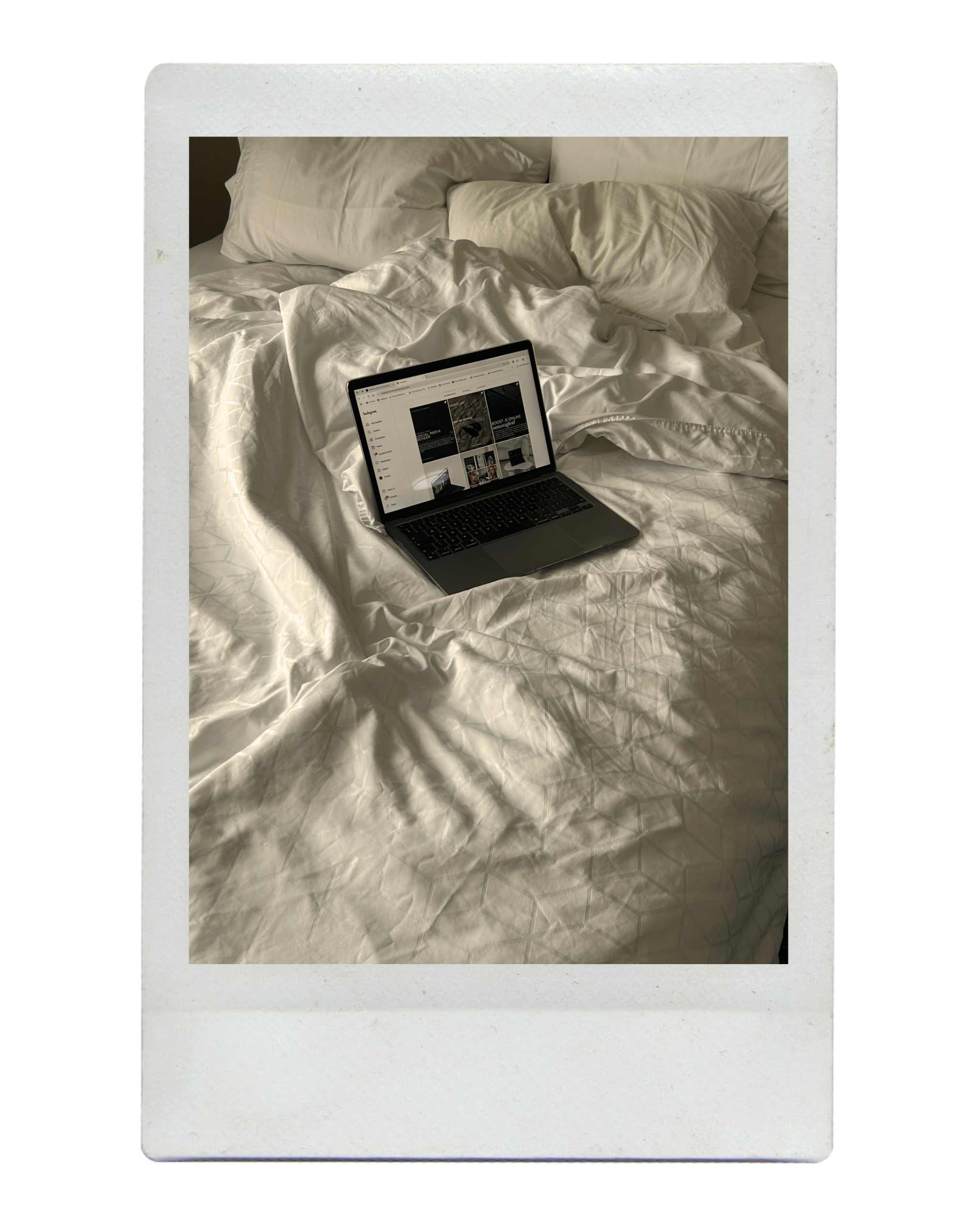 Laptop on unmade white bed with pillows and crumpled sheets.