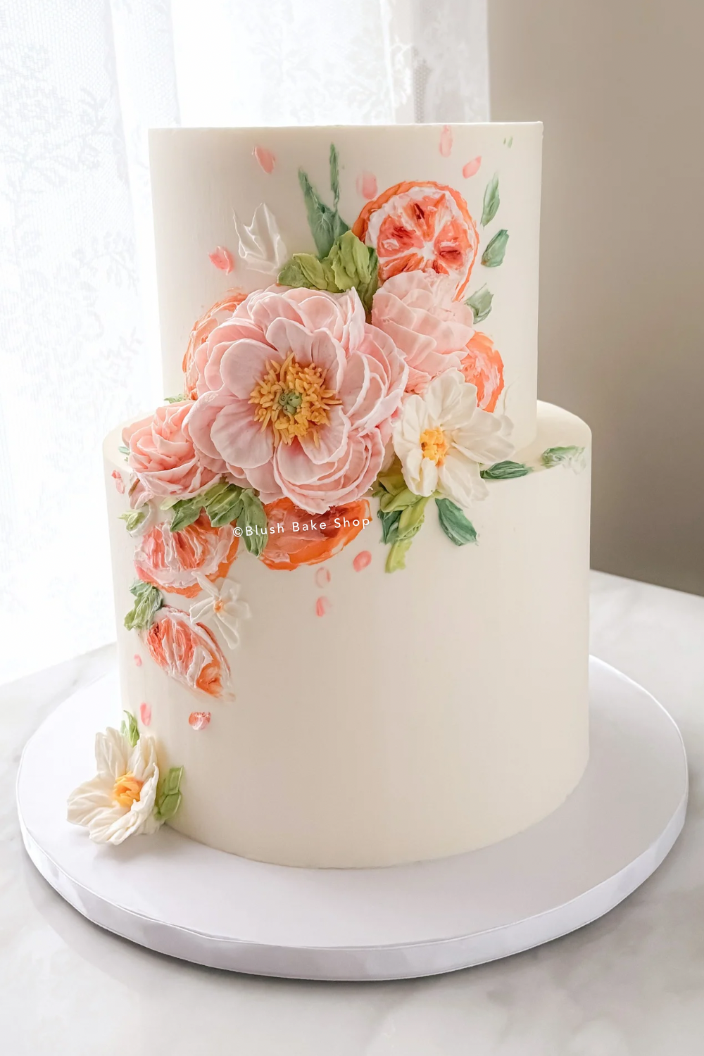 Citrus themed floral wedding cake in peach pink and orange in Phoenixville PA
