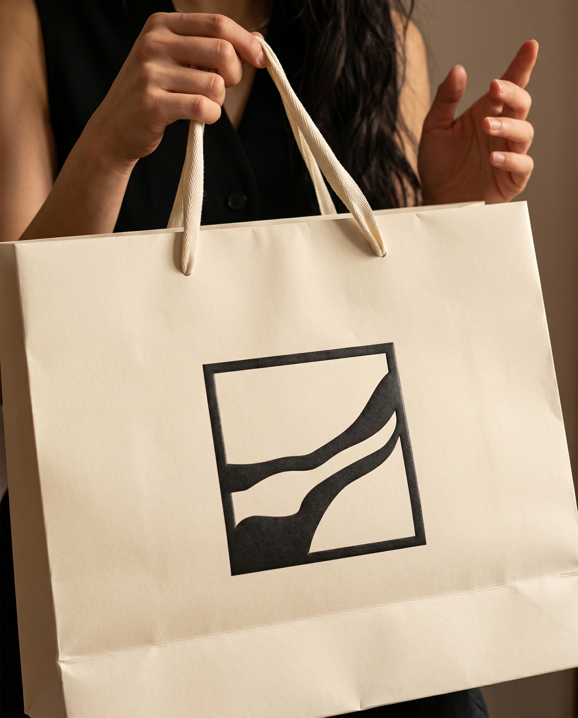 Logo Entwicklung, Logodesign, Custom logo, Eine Person hält eine weiße Tüte mit schwarzen Linien. Die Person trägt ein schwarzes Oberteil und hat lange dunkle Haare.