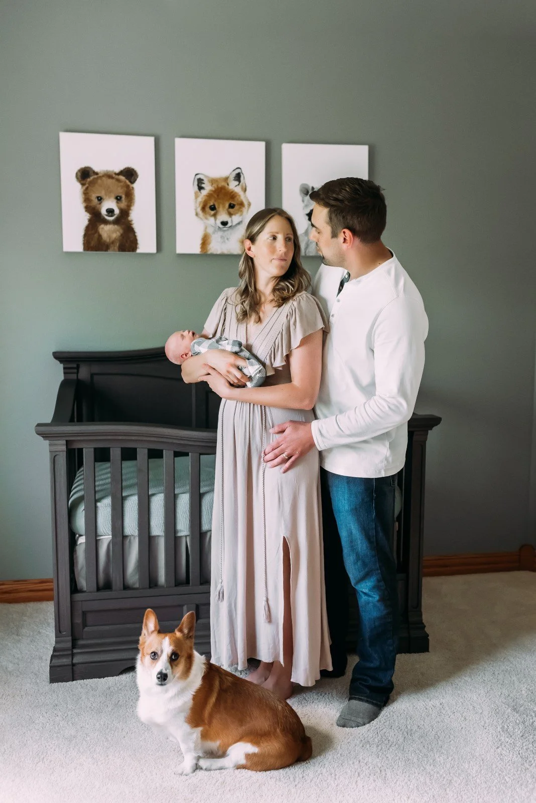 family and their dog snuggle in nursery during in home newborn session