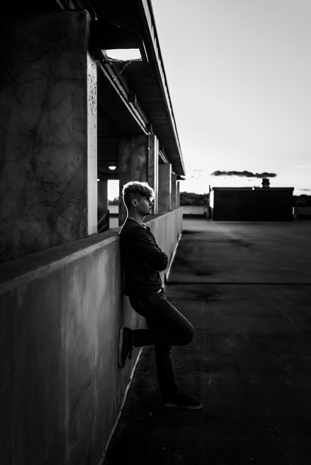 senior boy poses as sunset in downtown wausau wisconsin for unique senior photos