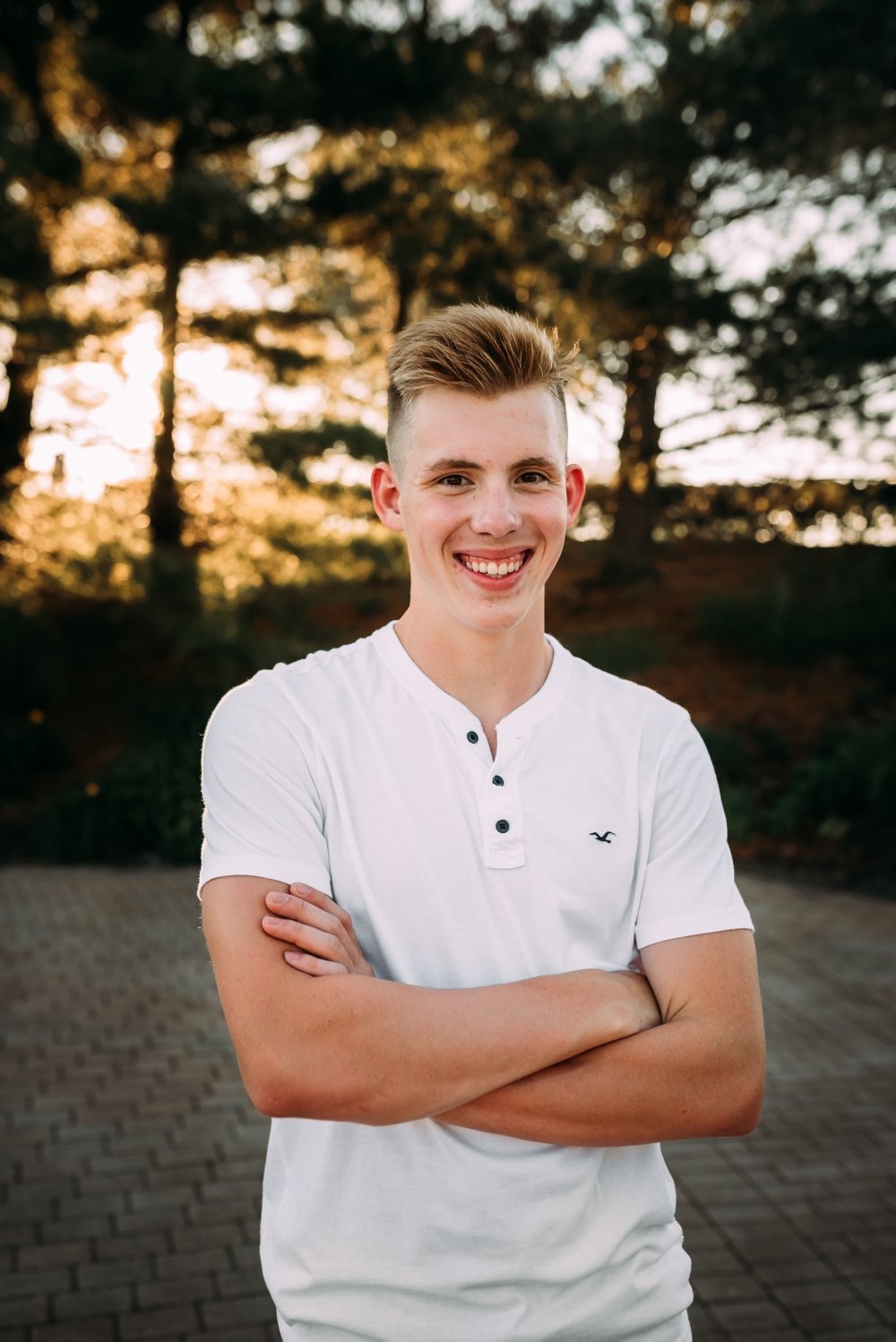 senior boy poses at lake michigan park at sunset