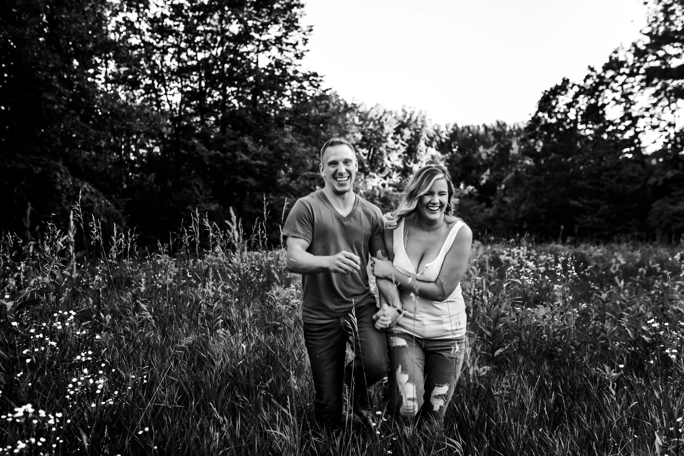 couple laughing and running together at their wausau engagement photo session