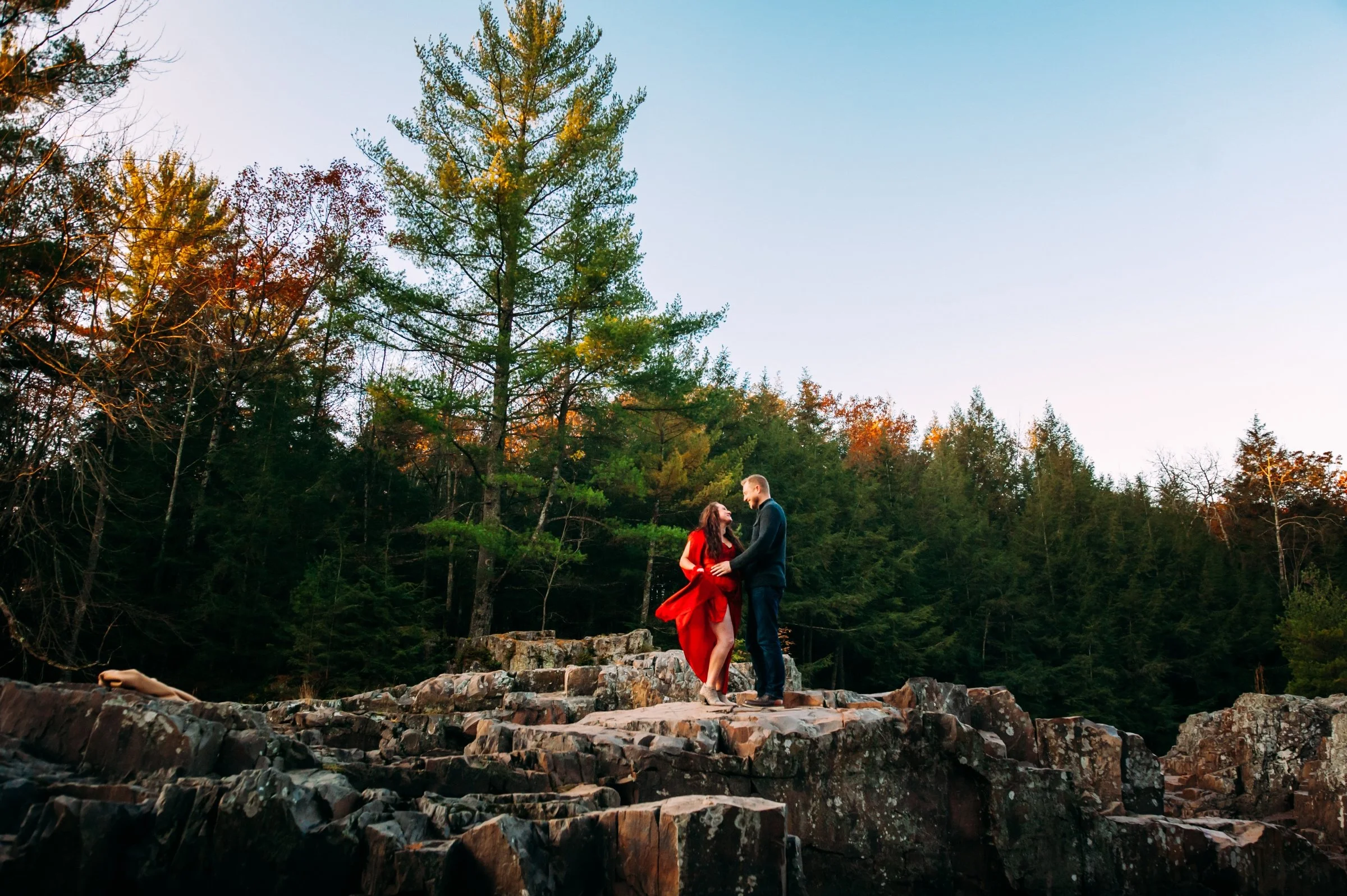 adventurous couple on top of rocks at their engagement session in wausau wi