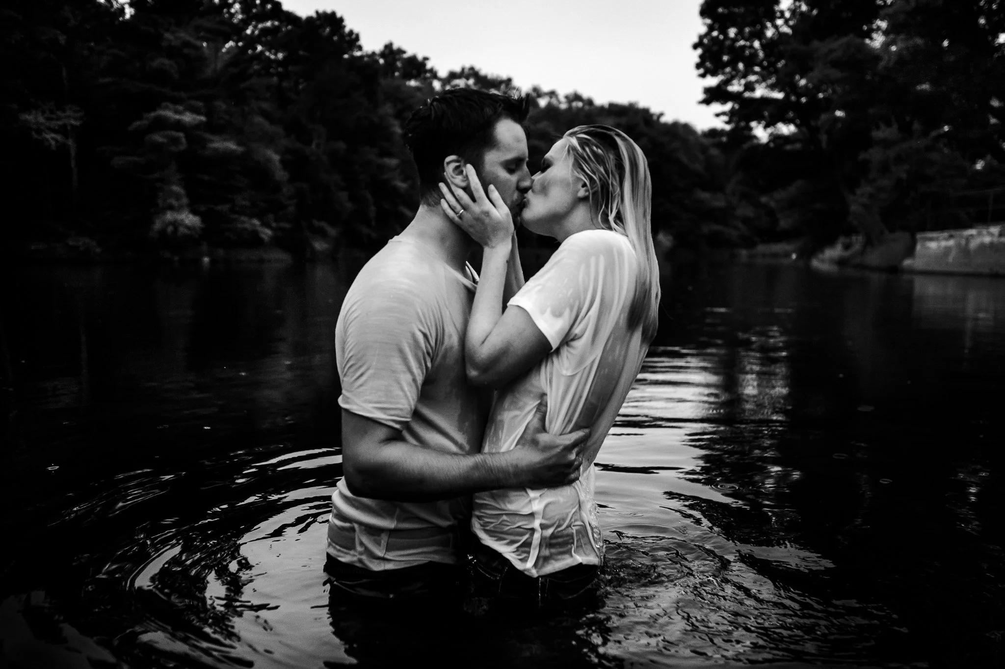 engaged couple passionately kiss in the water at eau claire dells during their wausau engagement session