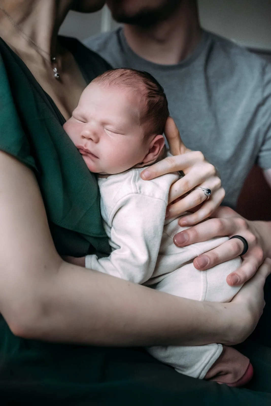 Newborn snuggled in parents arms during newborn photos in Wausau Wisconsin