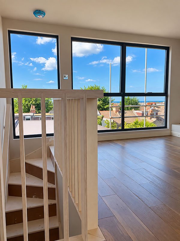 Dormer loft conversion with full-width glazing overlooking Brighton rooftops