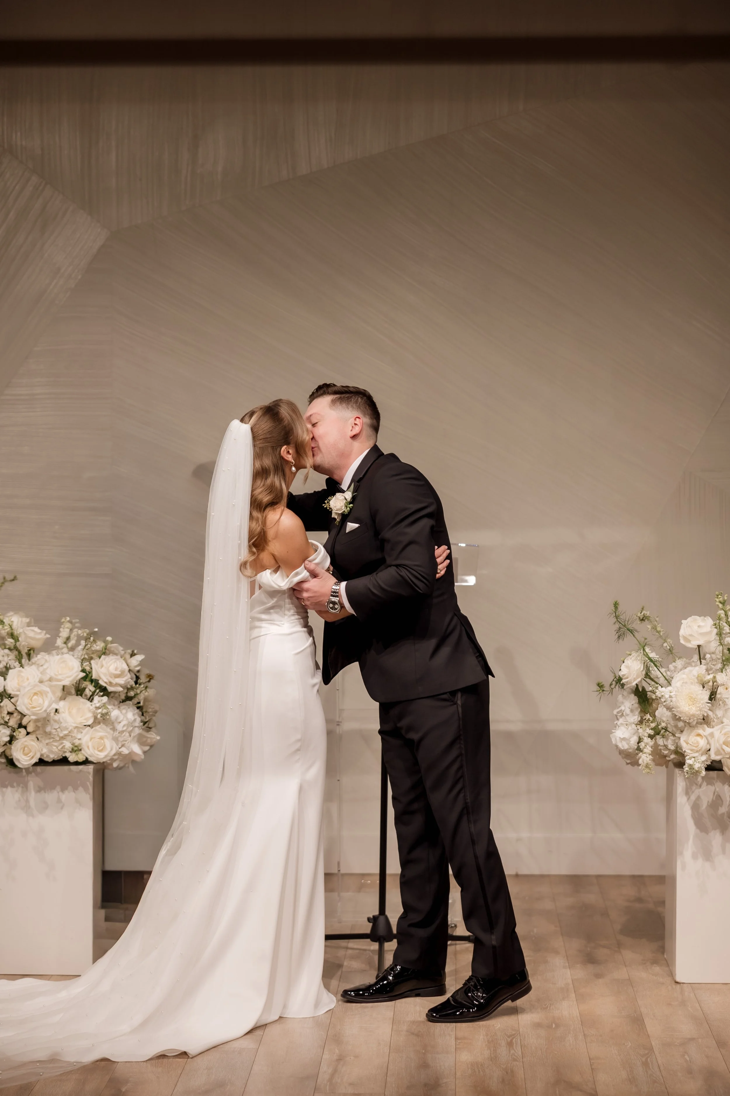 Bride and groom kiss at their indoor Walden Chicago wedding ceremony