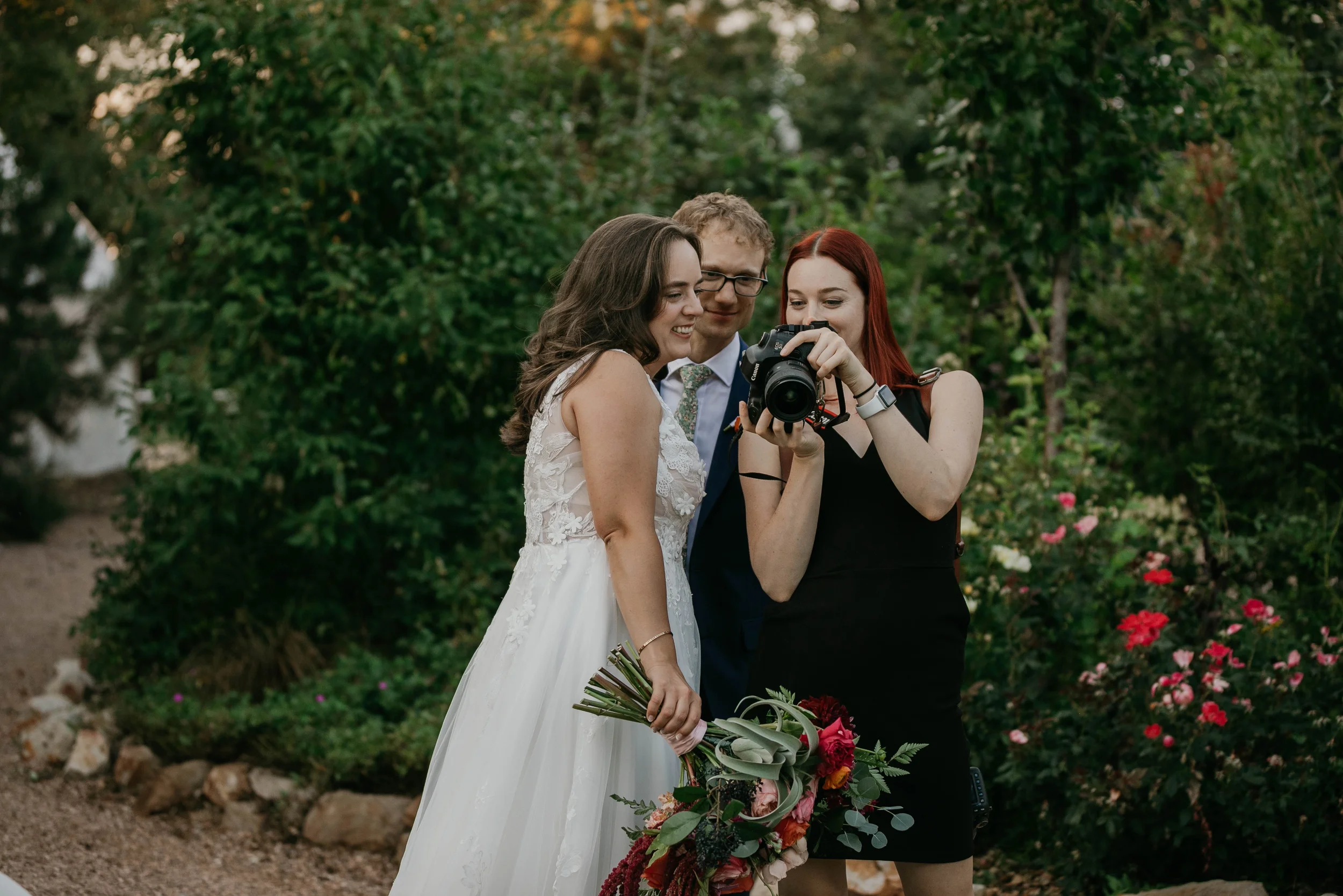 Candid photo of a wedding couple looking at their images on a camera with photographer Audrey Simper