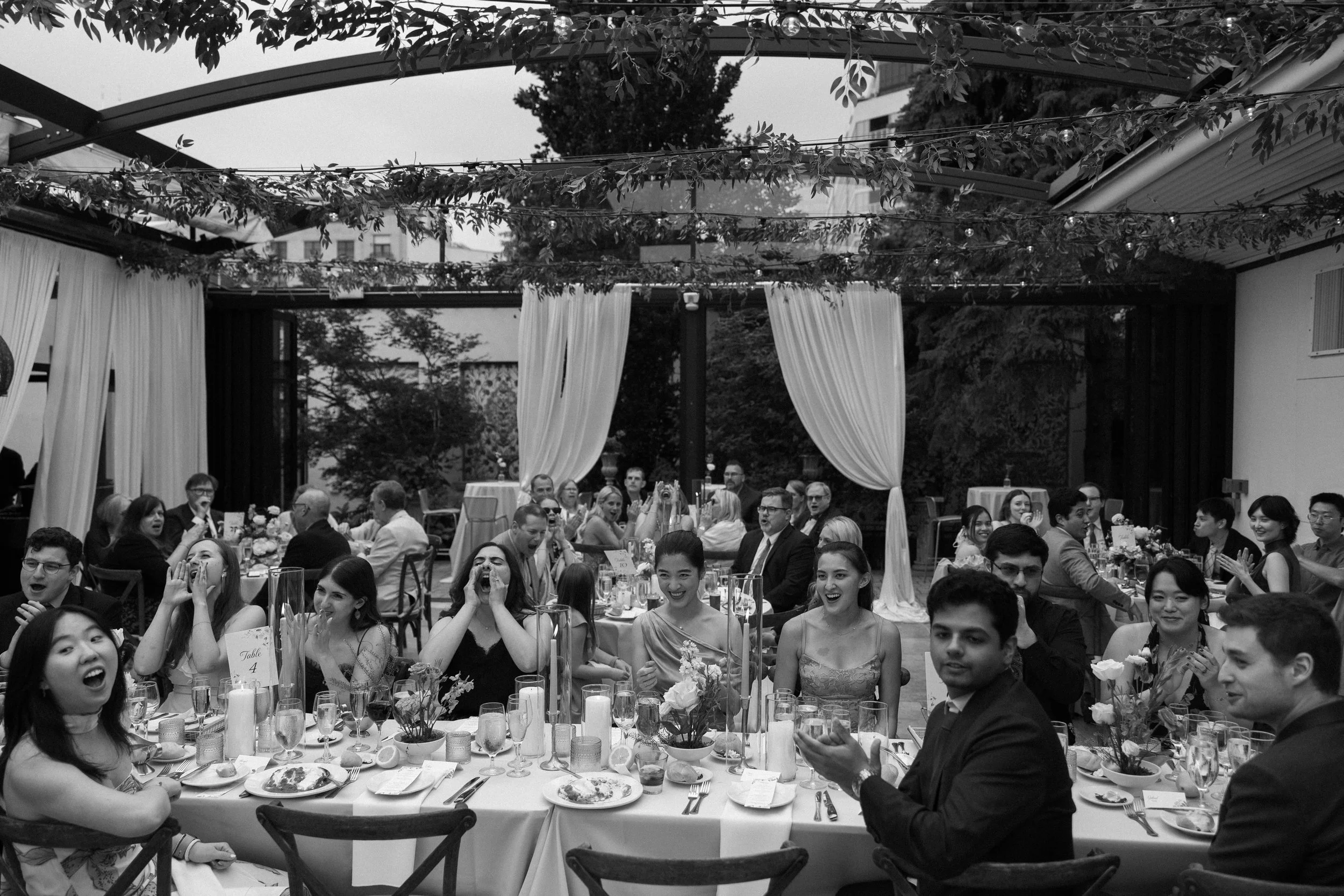 Guests sit at long tables at Galleria Marchetti La Pergola wedding reception