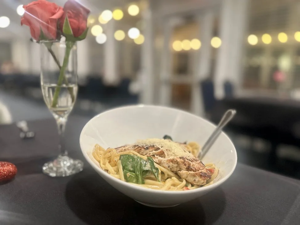 Close-up of two toasted sandwiches with melted cheese, ham, and possibly turkey, on a white plate. The sandwiches have grilled and browned bread with visible grill marks.