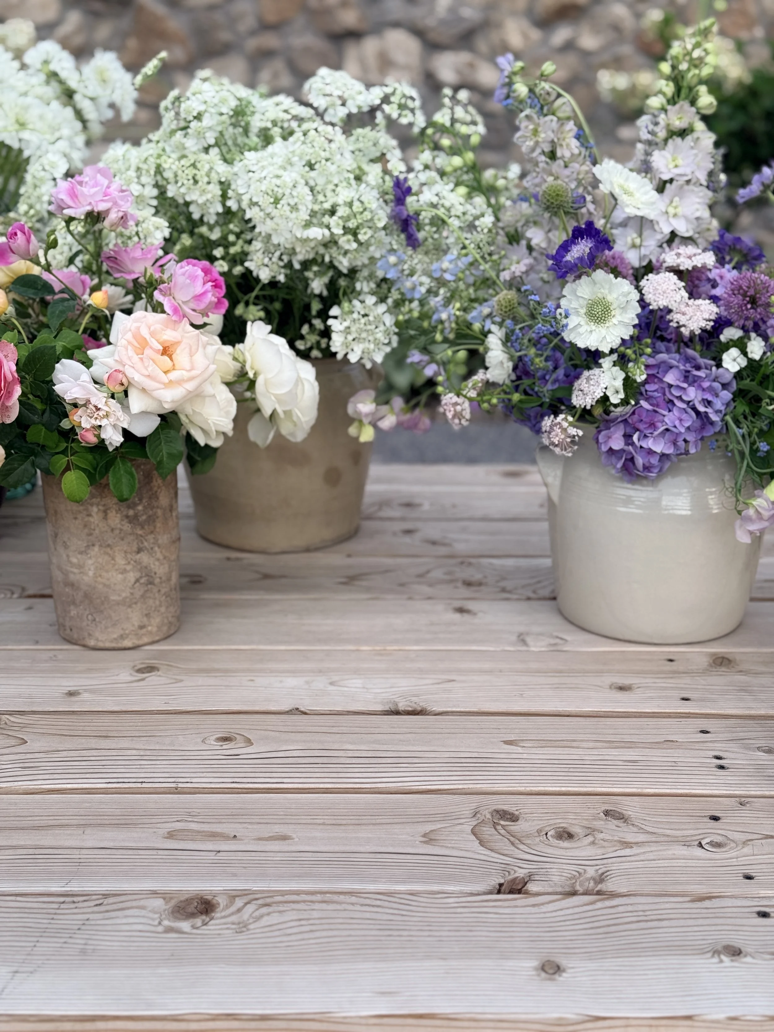 A bucket of bulk flowers being held by a farmer-florist 
