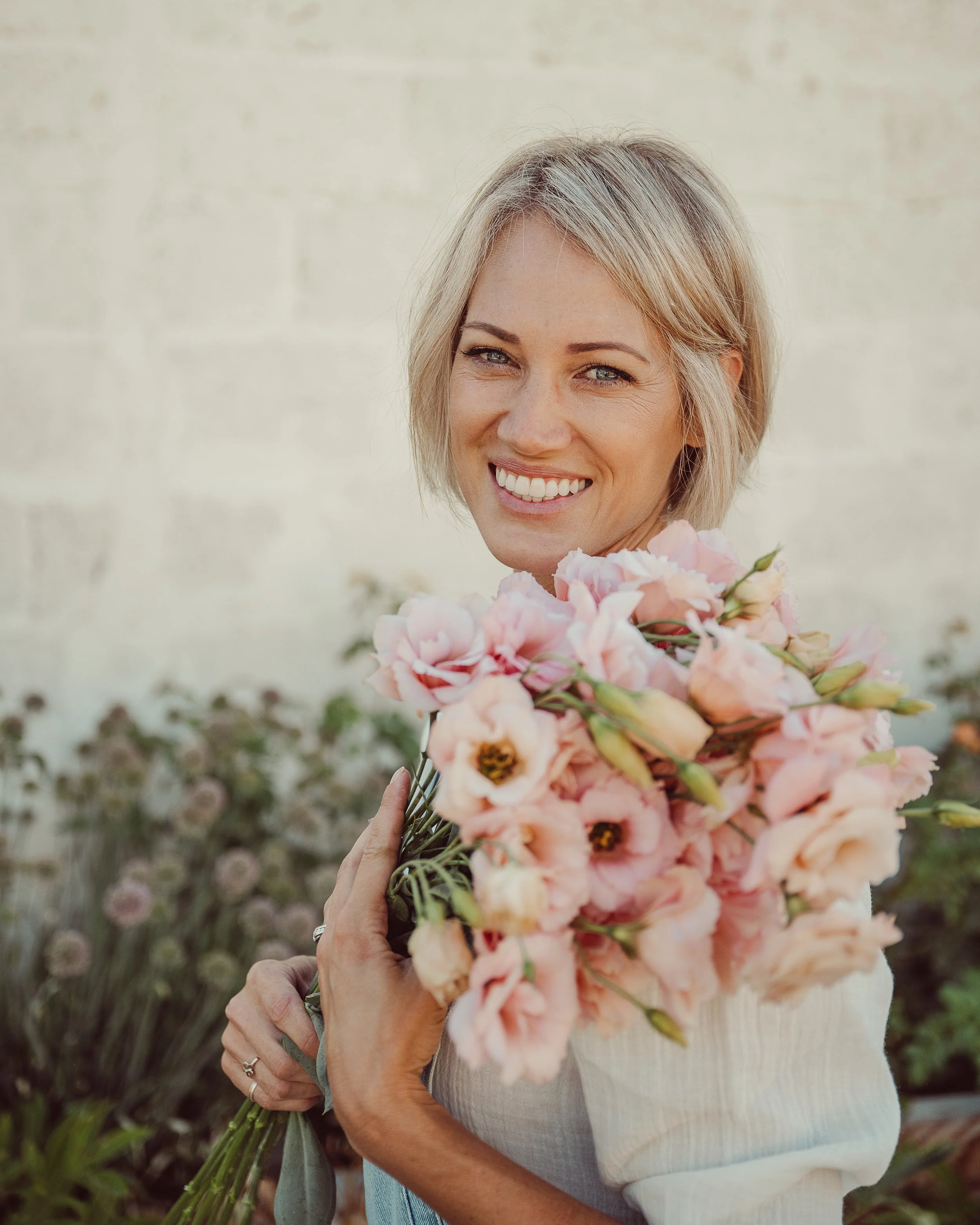 A flower farmer-florist holding pink weddign flowers for florists and brides
