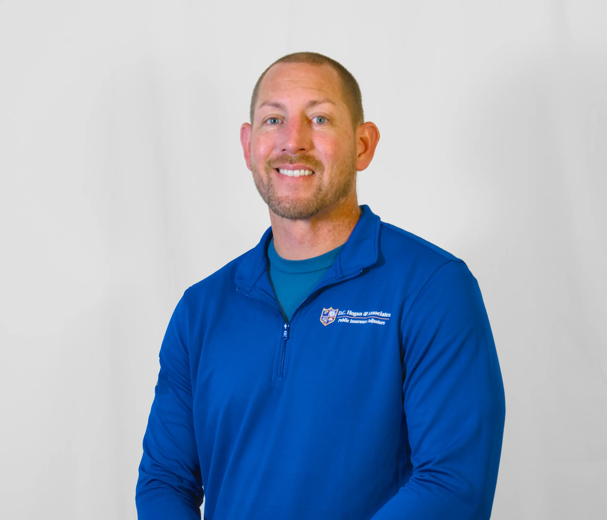 Headshot of Public Adjuster Greg Landry. He is a man wearing a long blue shirt.
