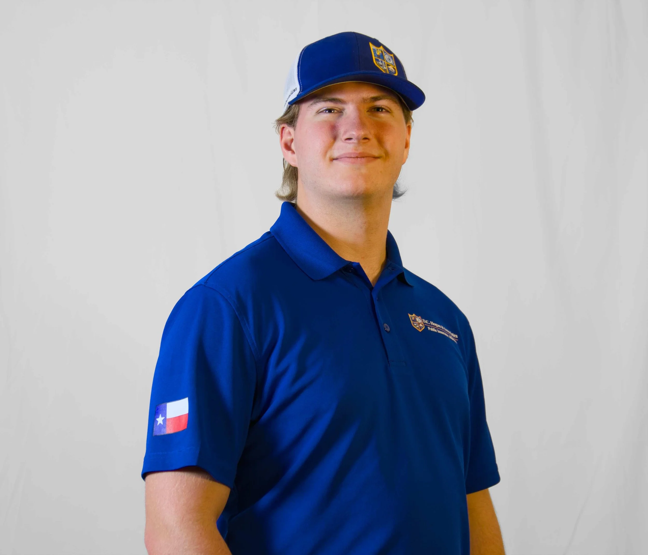 Noah Goodwin, a team member at D.C. Hogan & Associates. He is wearing a blue cap with a logo and a blue polo.