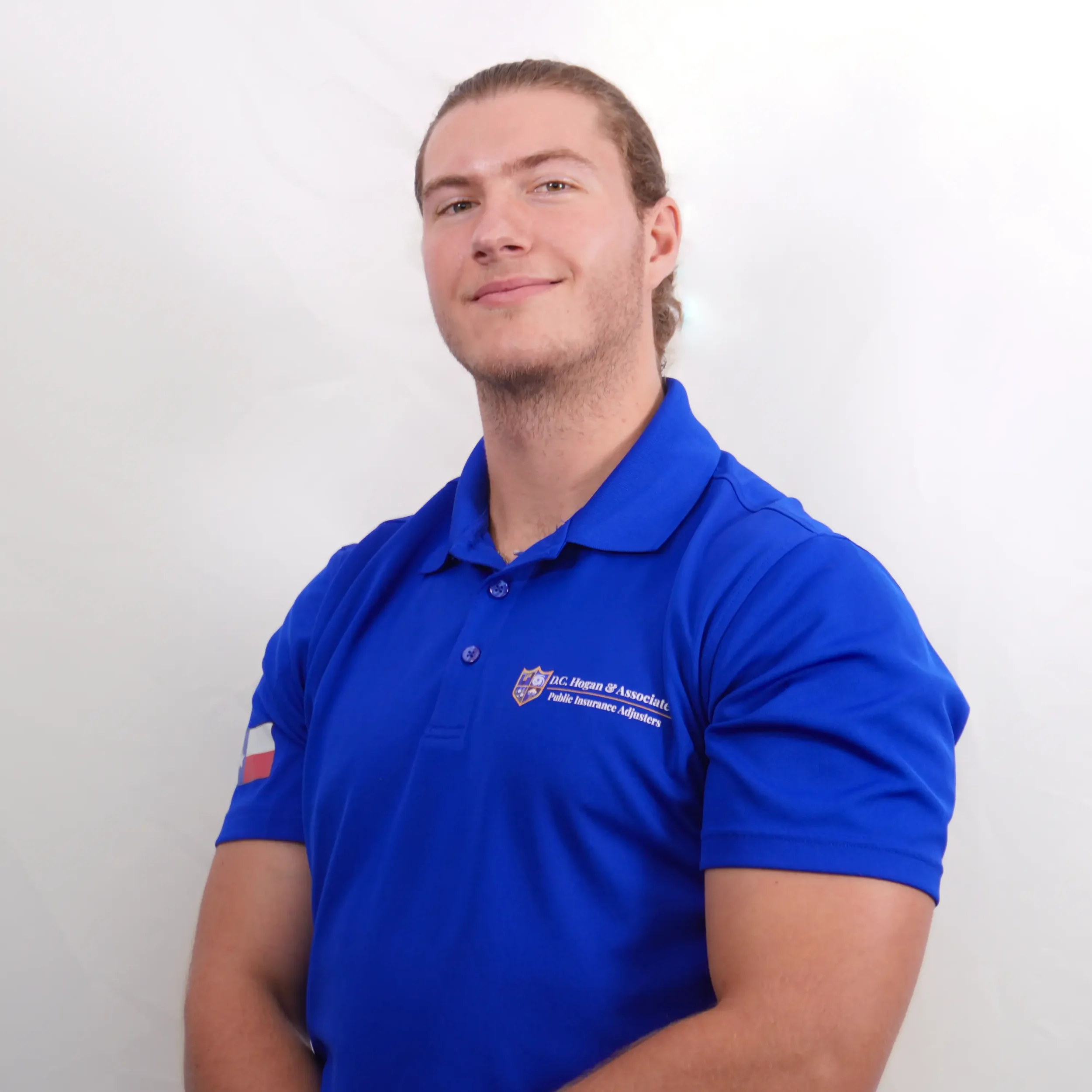 Noah Goodwin, a team member at D.C. Hogan & Associates. He is wearing a blue cap with a logo and a blue polo.