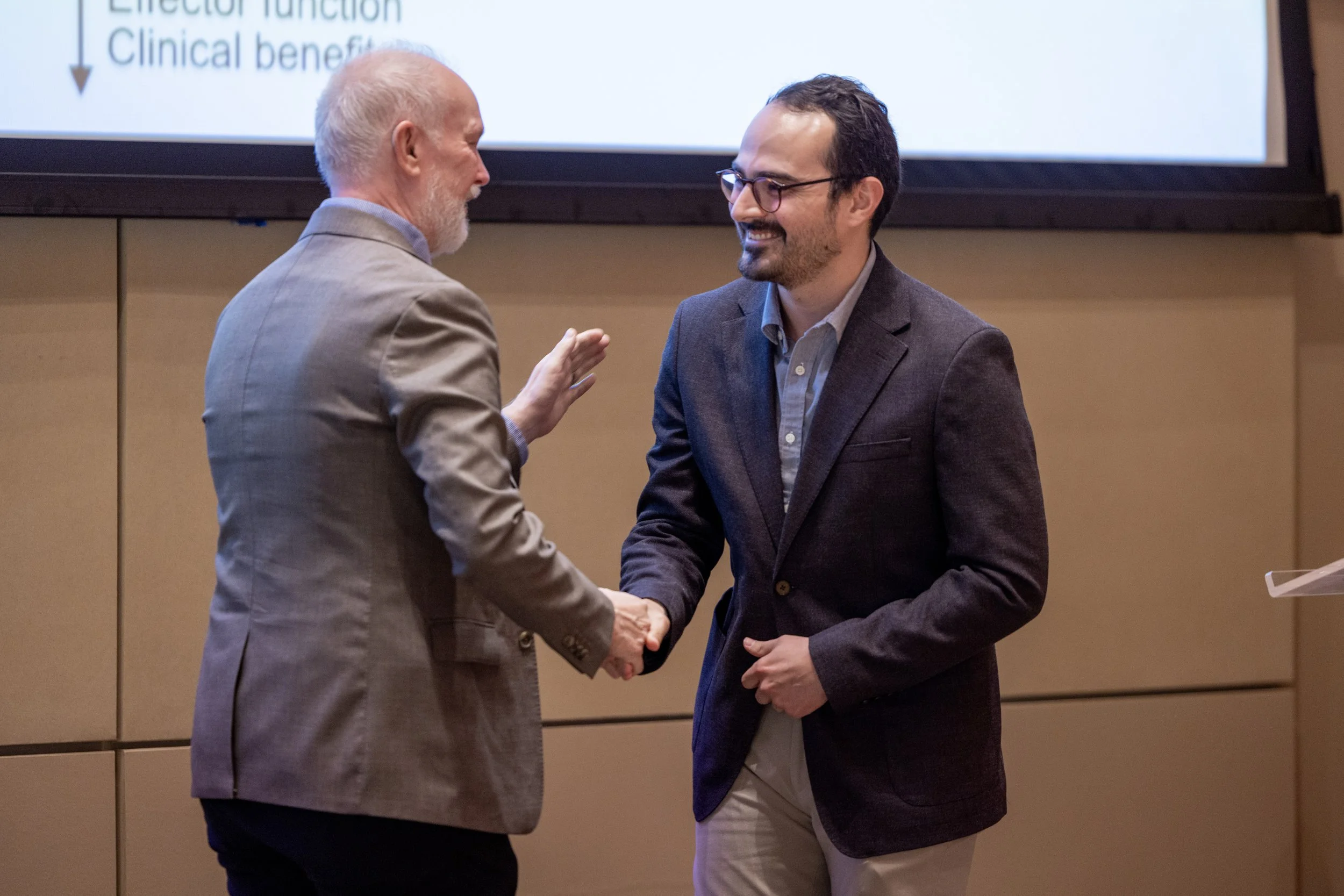 Christian shaking Colin Duckett's hand on stage.