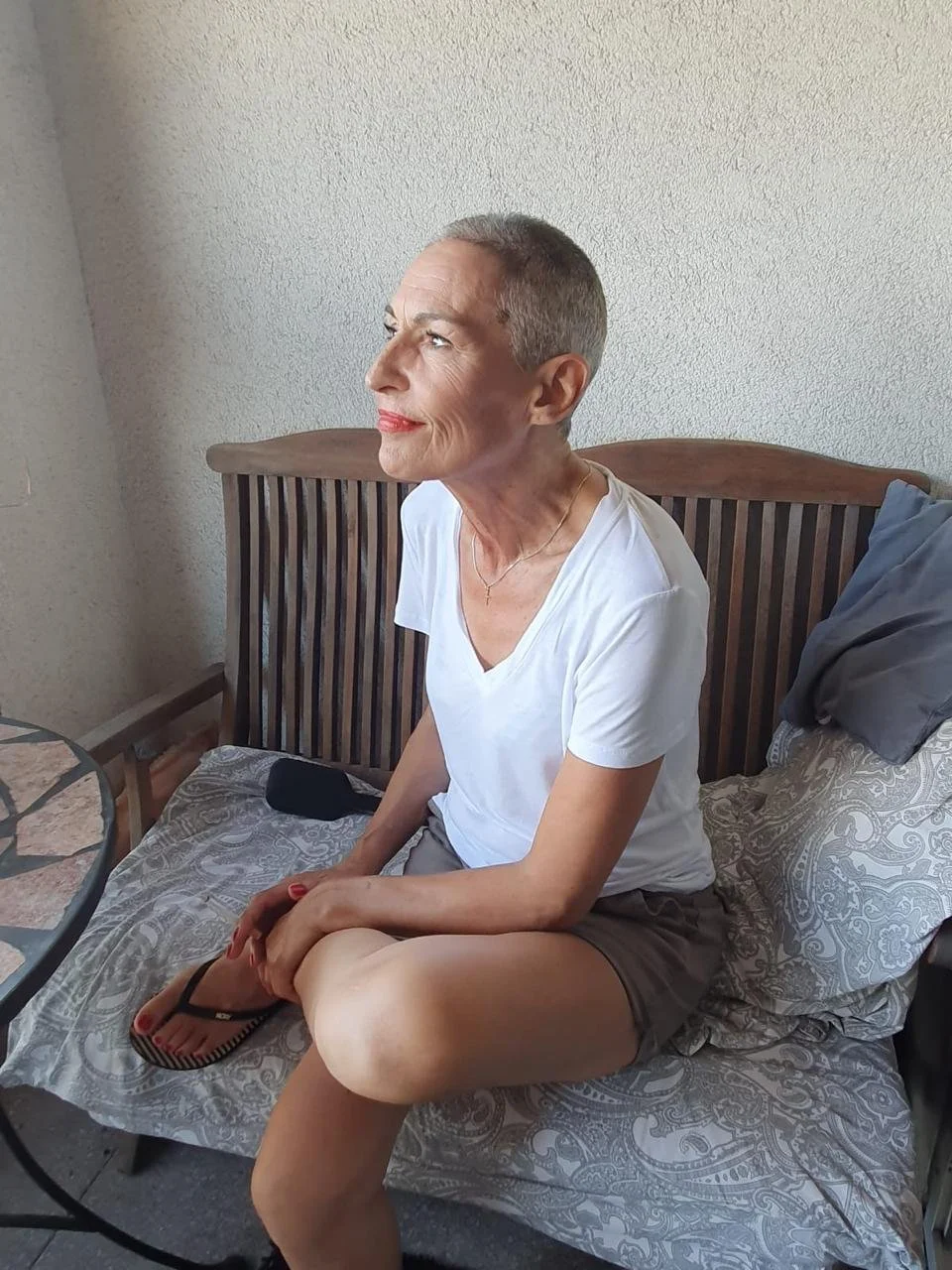 Wise and radiant in her late fifties — hair buzzed before chemo begins