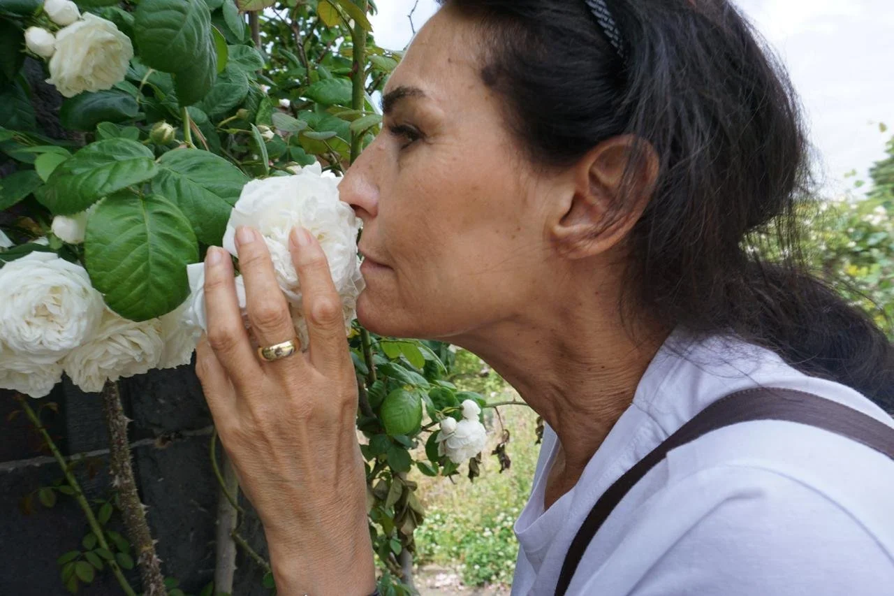My mother in her early fifties, smelling roses in the Botanical Garden, Berlin