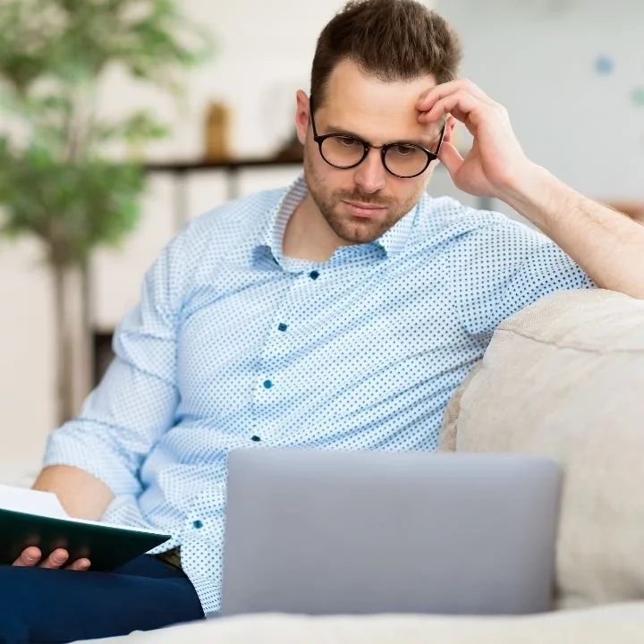 Man looking concerned while reviewing work on a laptop, illustrating ADHD-related attention and focus challenges.