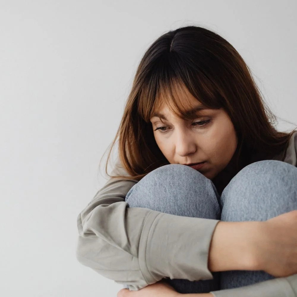 Sad woman curled up and deep in thought