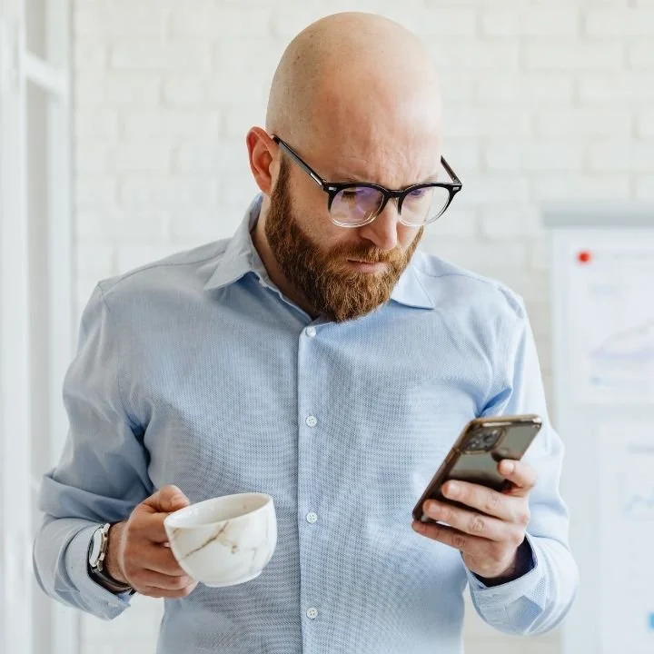 Person reading a message on their smartphone before a virtual mental health appointment.