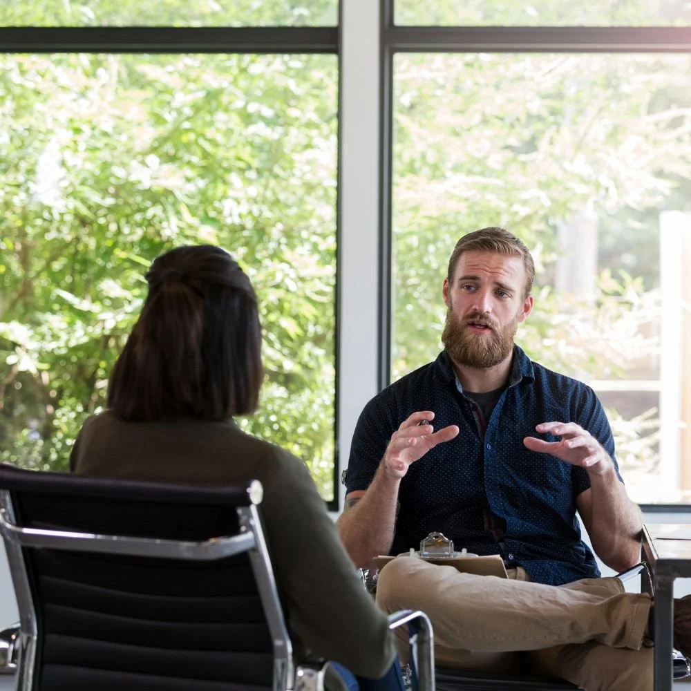 Man talking during therapy session near window