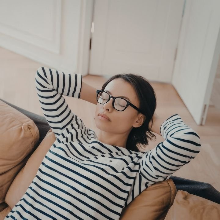 ✅ Woman leaning back with her eyes closed while taking a moment to pause and reflect.
