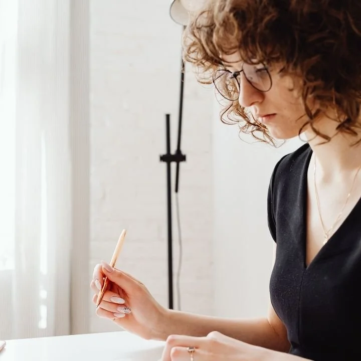 Young woman answering a questionnaire at desk with focused concentration quietly.