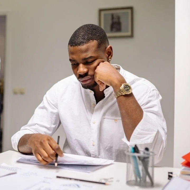 Man reviewing paperwork with concentrated expression.