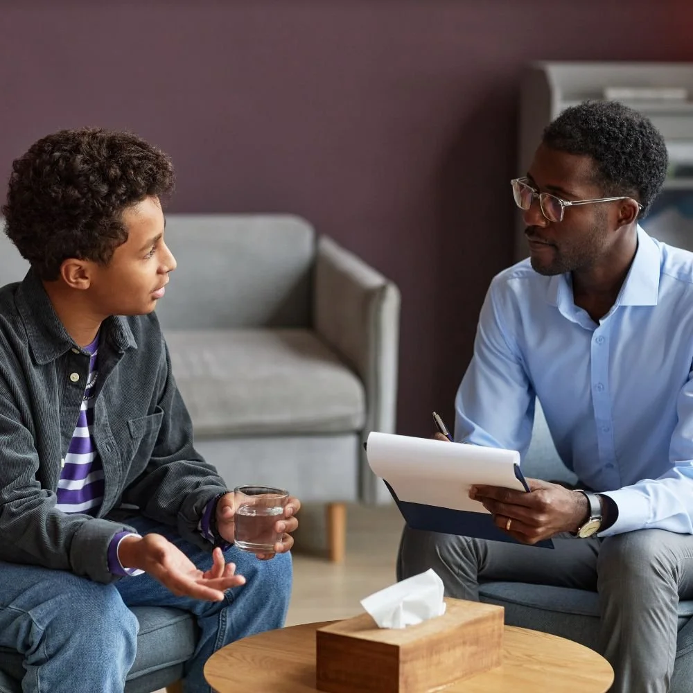Therapist listens attentively to boy during session