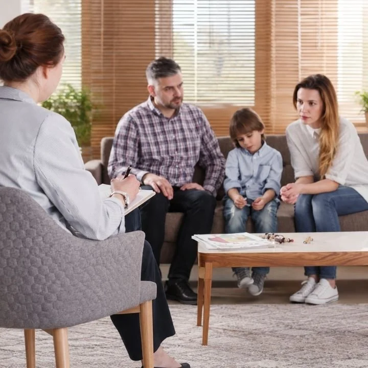 Parents discussing their child's behavior with a mental health professional during a consultation.