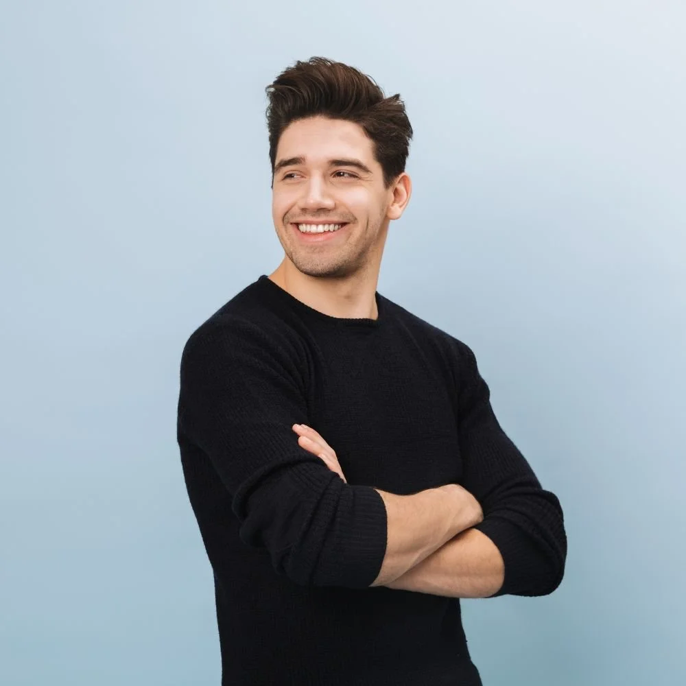 Smiling man with arms crossed, looking away