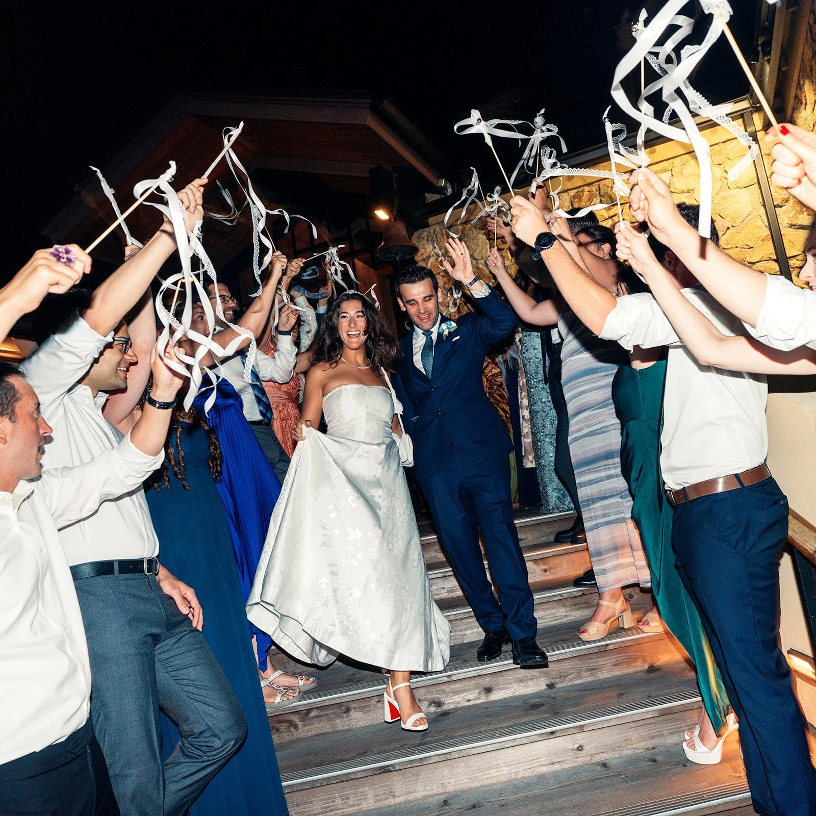 Newlyweds celebrate their wedding exit with guests waving ribbon wands outside Highlands Inn in Carmel-by-the-Sea.