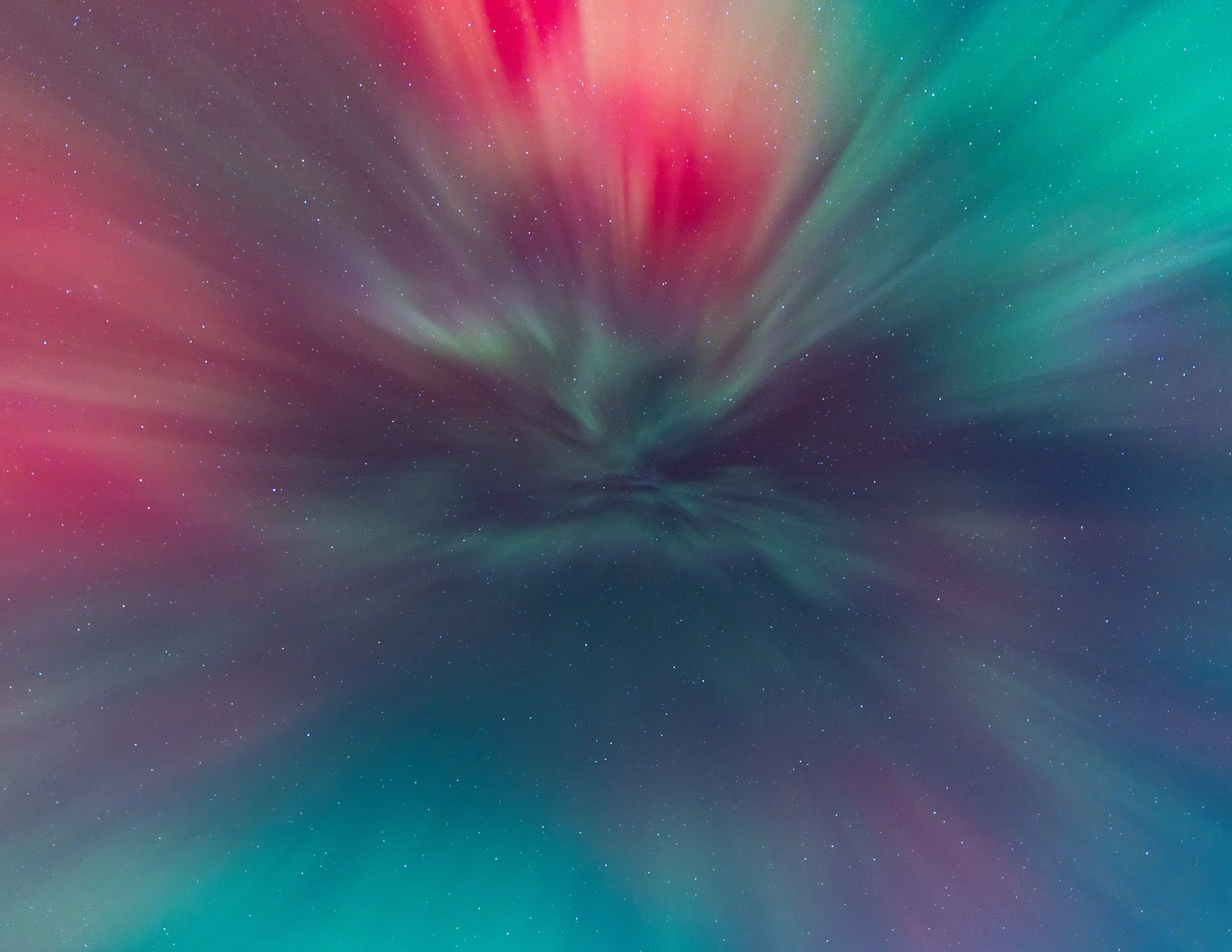 A digital depiction of the Northern Lights with red, green, and purple hues in the sky over a dark landscape with some stars visible.