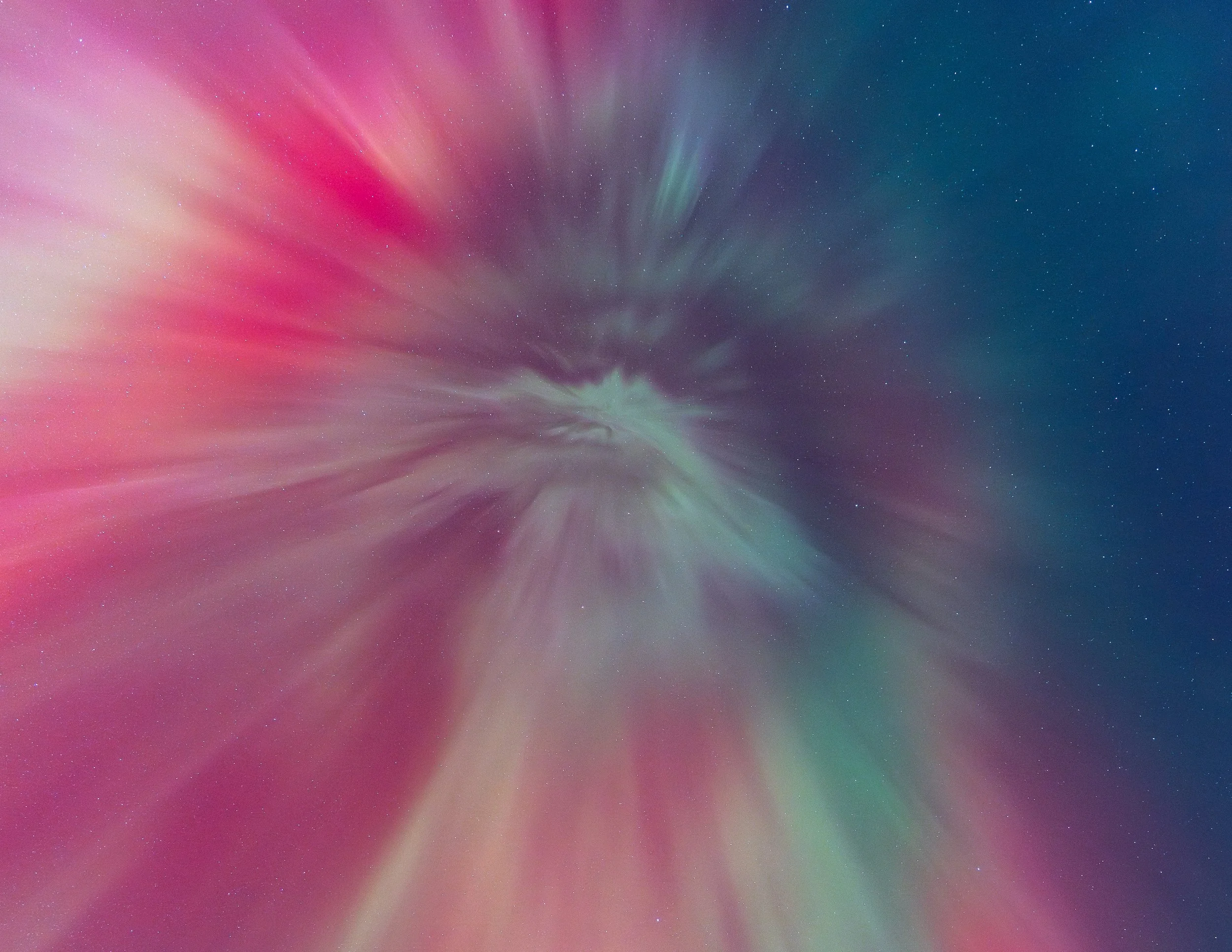 A colorful display of the Northern Lights (Aurora Borealis) in the night sky over a landscape with stars.