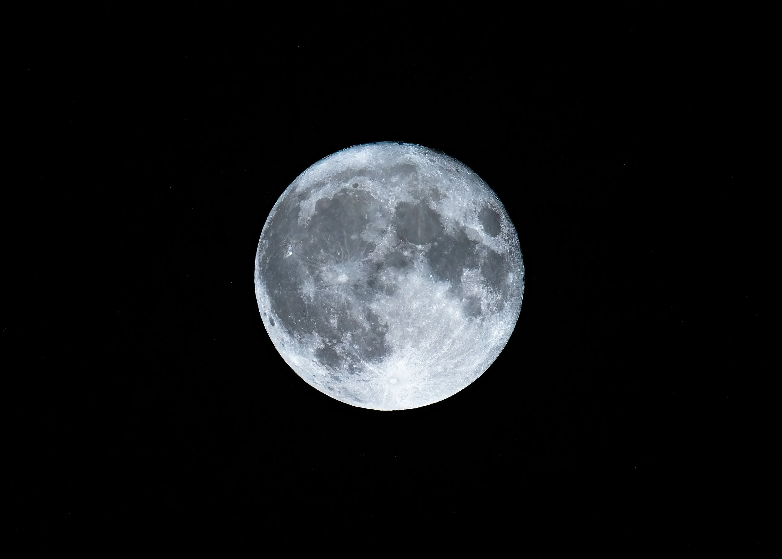 Full moon against a black night sky with a few visible stars